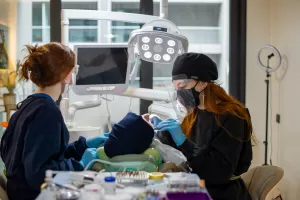 Dentist and nurse conducting a dental procedure using advanced equipment in a clinic setting.